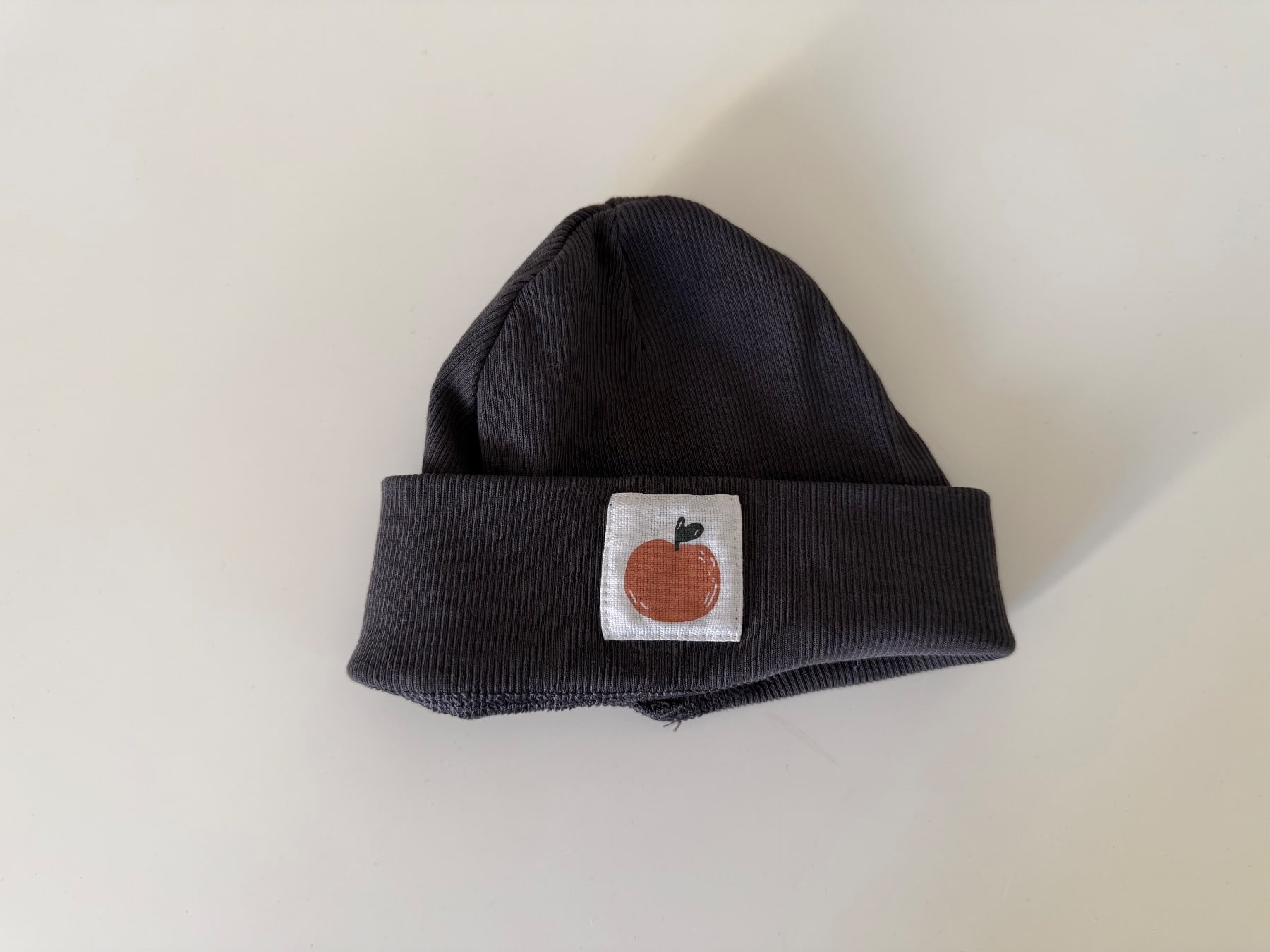 Schwarze Baby Mütze mit Apfel